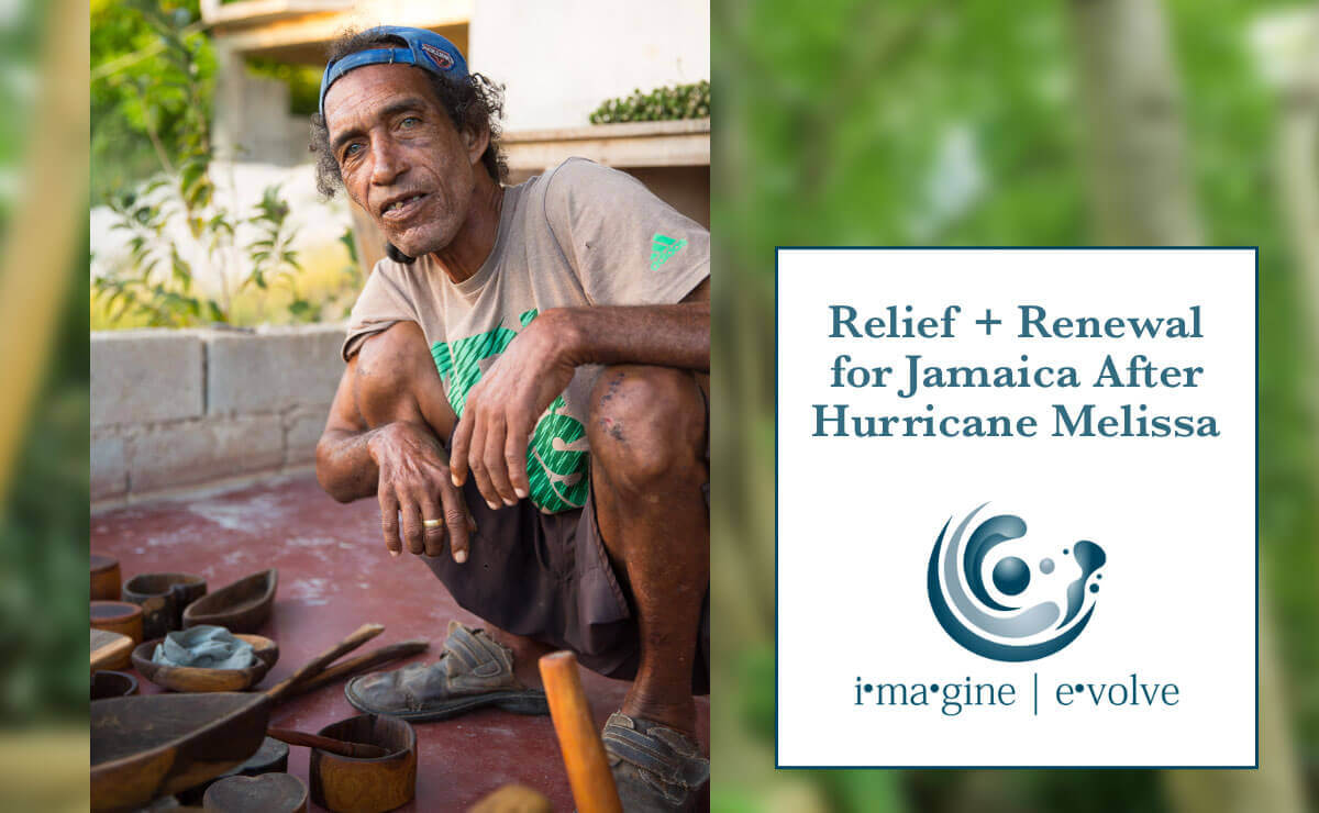 On the left side of the image is the following photo: On a red clay patio with a short brick wall in the background, a dark skinned Jamaican man squats with his hands draped over his knees and stares into the camera. He is wearing dark brown shorts, a sand colored t-shirt with a green design on the front, and a blue baseball cap turned backwards, and he has a simple gold ring on the middle finger of his right hand. Before him on the patio are a collection of roughly hewn wooden bowls and utensils. On the right side of the image is a white box with the following in dark blue text: “Relief + Renewal for Jamaica after Hurricane Melissa.” Below that, in the same dark blue, is the logo for “imagine | evolve.”