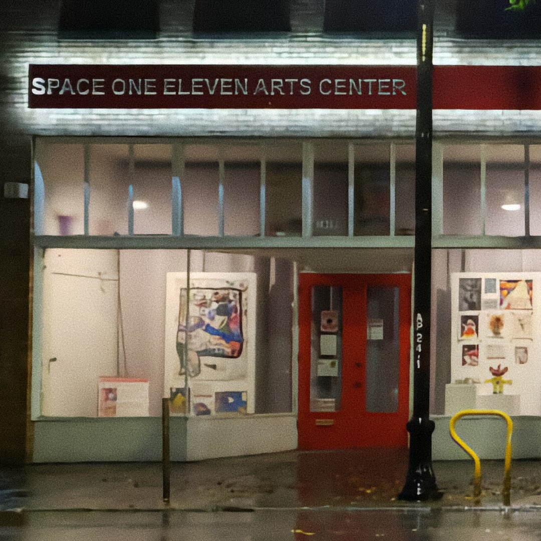 A street view at night of the front of Space One Eleven Arts Center, a converted storefront with white or pale green trim and a pair of red doors. Paintings, drawings, and a small yellow and red sculpture are arranged behind the large glass display windows on either side of the doors. A long red sign above the storefront has the words “Space One Eleven Arts Center” cut out and illuminated from behind, so that the words are lit up and a white glow extends out behind the sign and across the bricks of the wall.