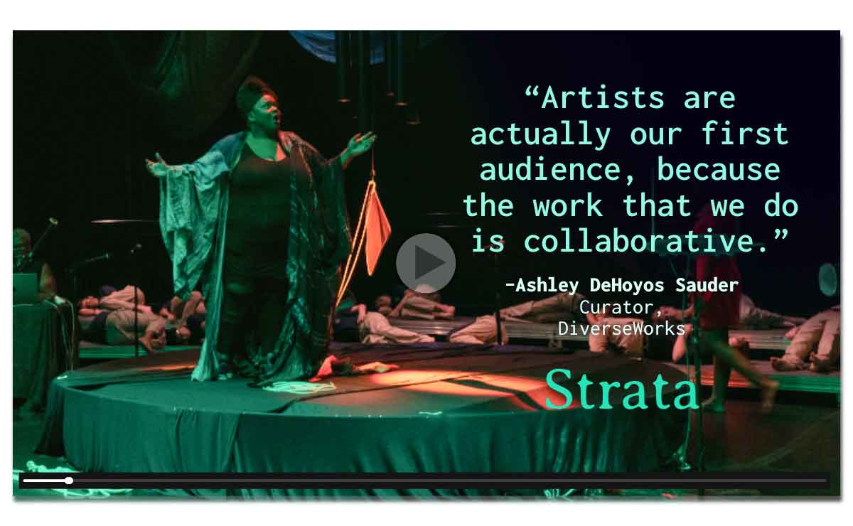 Video still with a play button in the center and a progress bar across the bottom. The still features a darkened performance space lit mostly by green lights with orange accent lighting. A Black woman stands on a cloth-covered circular dais and sings with her arms held out. She is wearing a black turban and a robe of light and dark patterns over black pants and a black shirt. Behind her, nearly a dozen performers, all wearing matching khaki pants and blue shirts, are spread across the floor in sleeping poses. On the right of the dais, between the singing woman and the sleeping performers, a barefoot woman wearing a short red dress is walking, but she is obscured from the waist up by overlaid text in light green that shows a quote and the Strata logo. The quote reads, “Artists are actually our first audience, because the work that we do is collaborative.” Underneath that is the speaker credit, “Ashley DeHoyos Sauder, Curator, DiverseWorks.” Below that is the word “Strata” in the series font. 