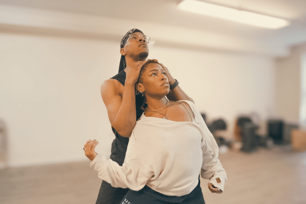 A medium-skinned African American man embraces a medium-skinned African American woman as they look to the sky.