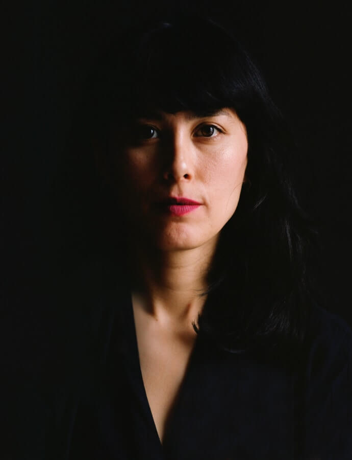 A promotional head shot of the artist Aretha Aoki.