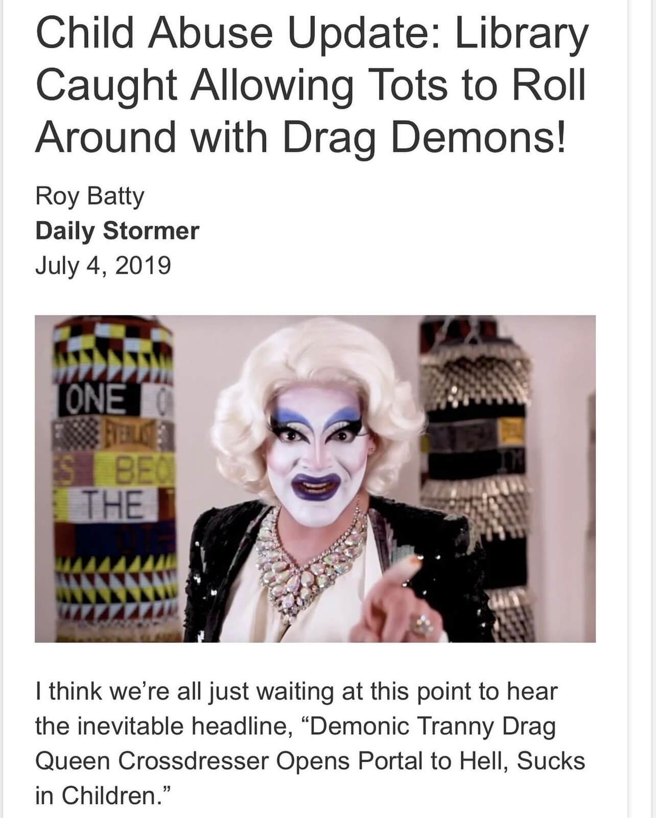 Screen shot of an online article from Daily Stormer. The headline reads, "Child Abuse Update: Library Caught Allowing Tots to Roll Around with Drag Demons!" The accompanying photo shows Carla Rossi in a medium-length white wig and dark violet lipstick, wearing an embroidered black jacket with padded shoulders and pointing at the camera. Below the photo is the following text: "I think we're all just waiting at this point to hear the inevitable headline, 'Demonic Tranny Drag Queen Crossdresser Opens Portal to Hell, Sucks in Children.'"
