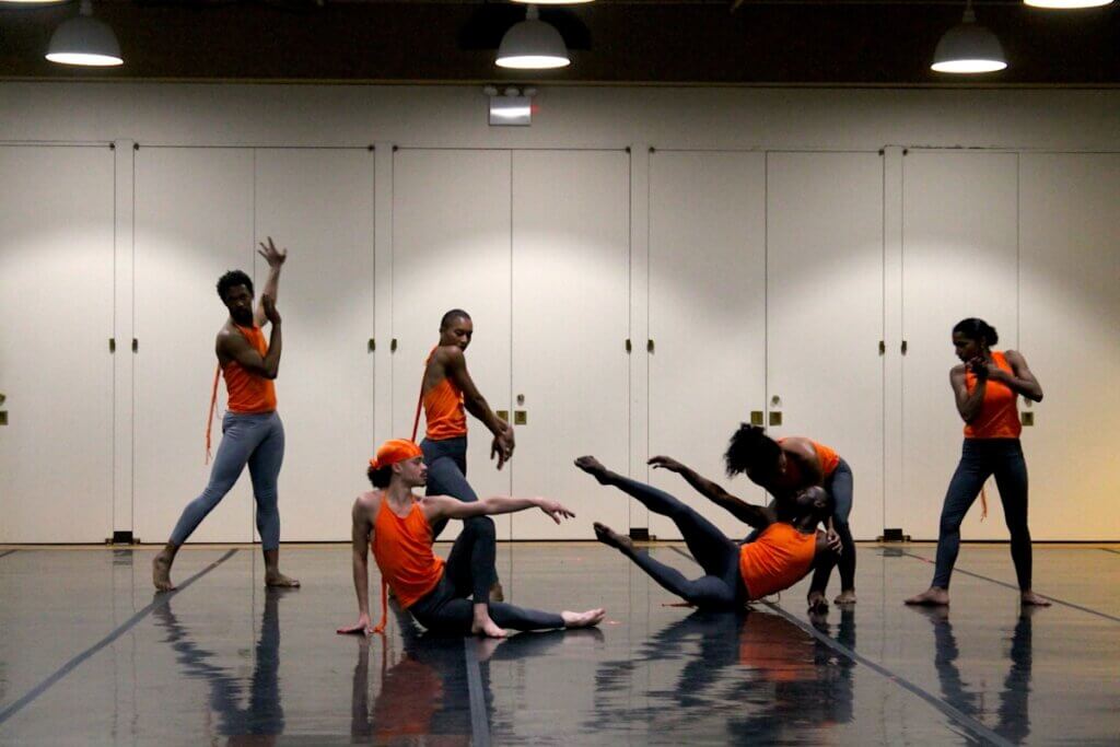 6 Black and Brown performers pose in a group tableaux