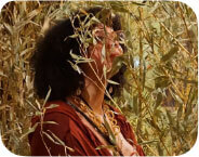 A Black woman stands in a bamboo forest.