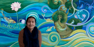 Geeta Dave sits with one of her finished murals.
