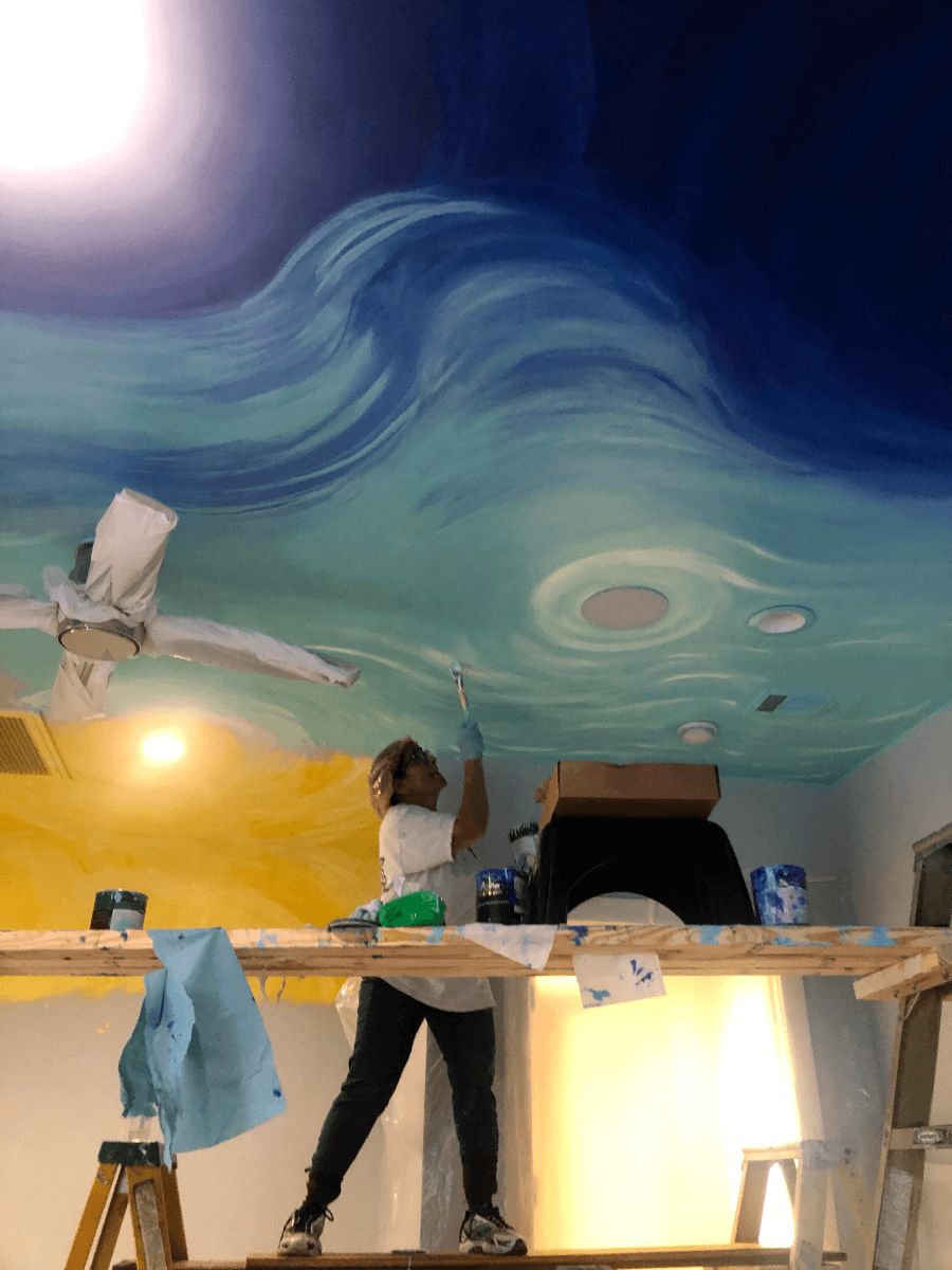 Geeta Dave painting a ceiling.