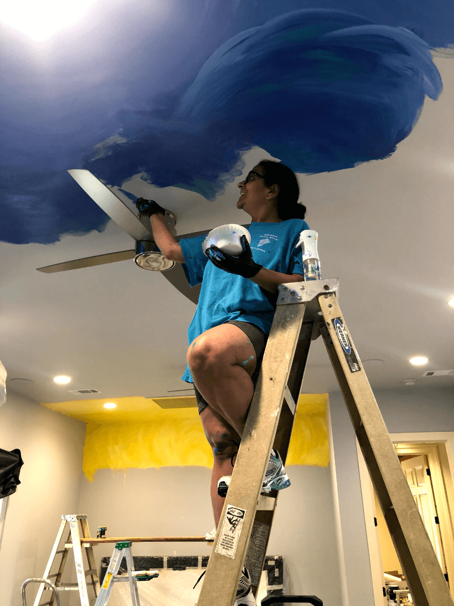 Geeta Dave painting a ceiling.