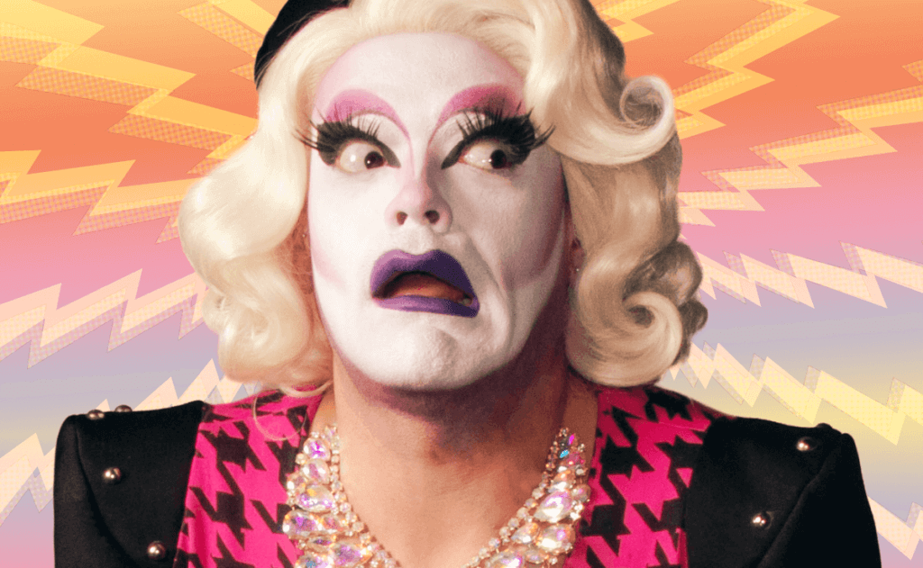 Drag performer Carla Rossi, wearing a bold makeup look featuring black, smoky eyes and purple lipstick and wig.